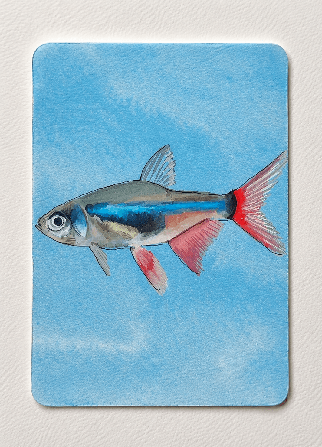 Watercolor painting of a neon tetra fish with a glowing blue stripe and red fins.